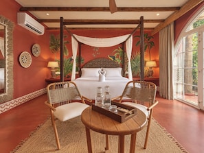 A room with a bed, two chairs, a table, and a large window. - Khubani Resort (Ashvem)