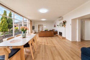 A spacious living area with a dining table, sofas, and a fireplace.