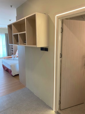 A hotel room with a bed, a built-in wardrobe, and a door with a light strip. - Apartment in Pattaya (Pattaya City)