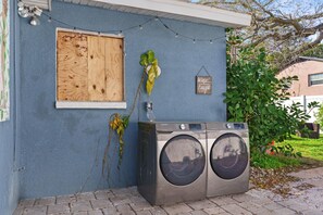 Un espace buanderie équipé d’un lave-linge et doté d’une porte en bois.