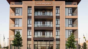 Un edificio de varios pisos con techo plano y un cartel que dice 'SAMARQAND'.
