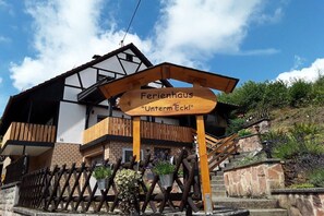 A wooden sign with the text 'Ferienhaus 'Unterm Eck!''. - Holiday home with 1 bedroom (Elmstein \/ Iggelbach)
