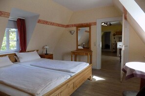 Een slaapkamer met een groot bed, een nachtkastje, een spiegel en een deur naar een badkamer.