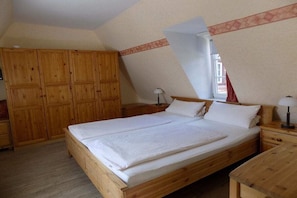 A bedroom with a wooden bed, a wardrobe, and a nightstand. - Holiday apartment with 1 bedroom (Freinsheim)