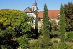 A church with a steeple, surrounded by greenery and trees. - Holiday apartment with 1 bedroom (Freinsheim)