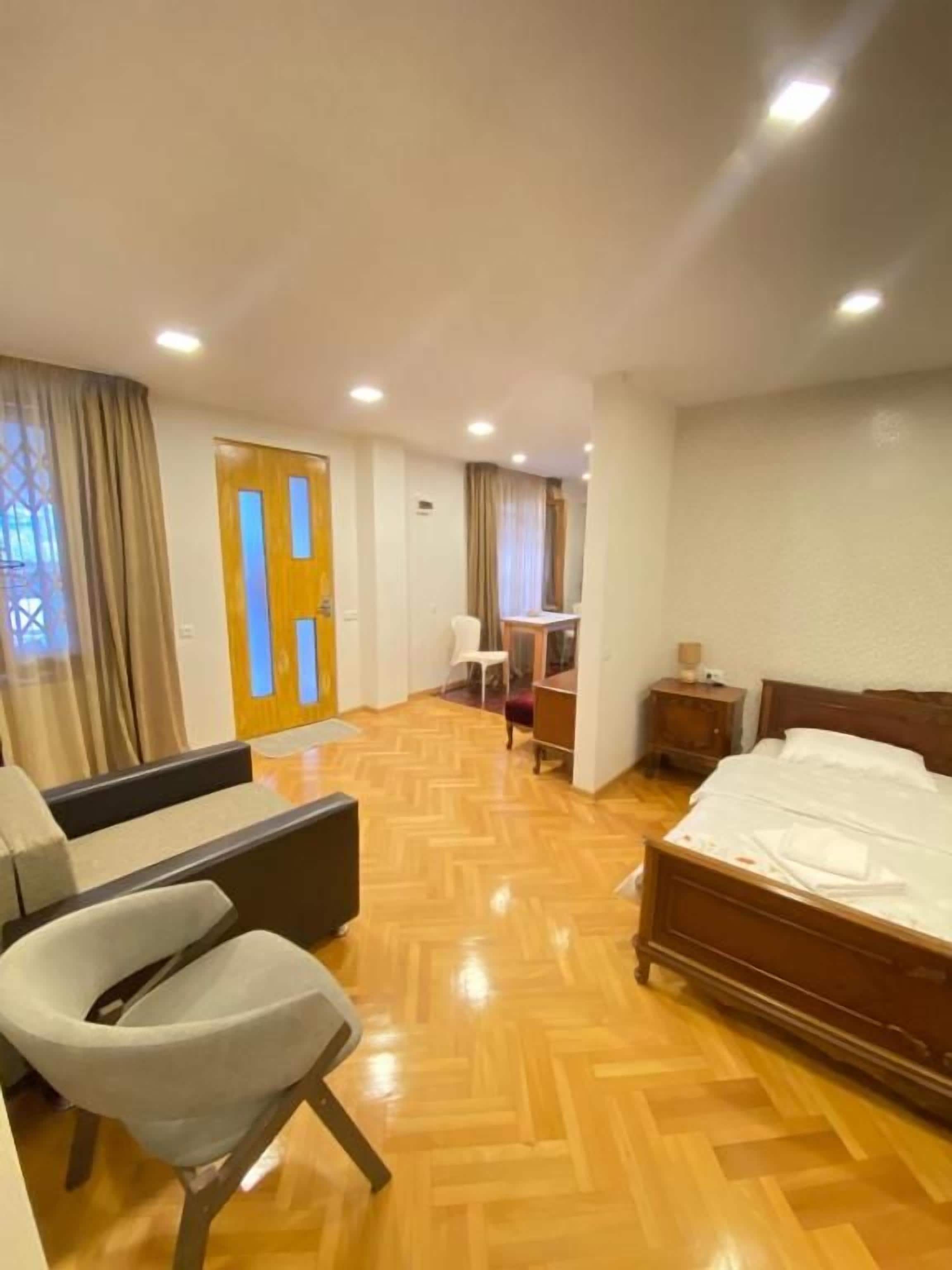 Une chambre d’hôtel comprenant un lit, un canapé, une chaise, un bureau et une table de chevet.