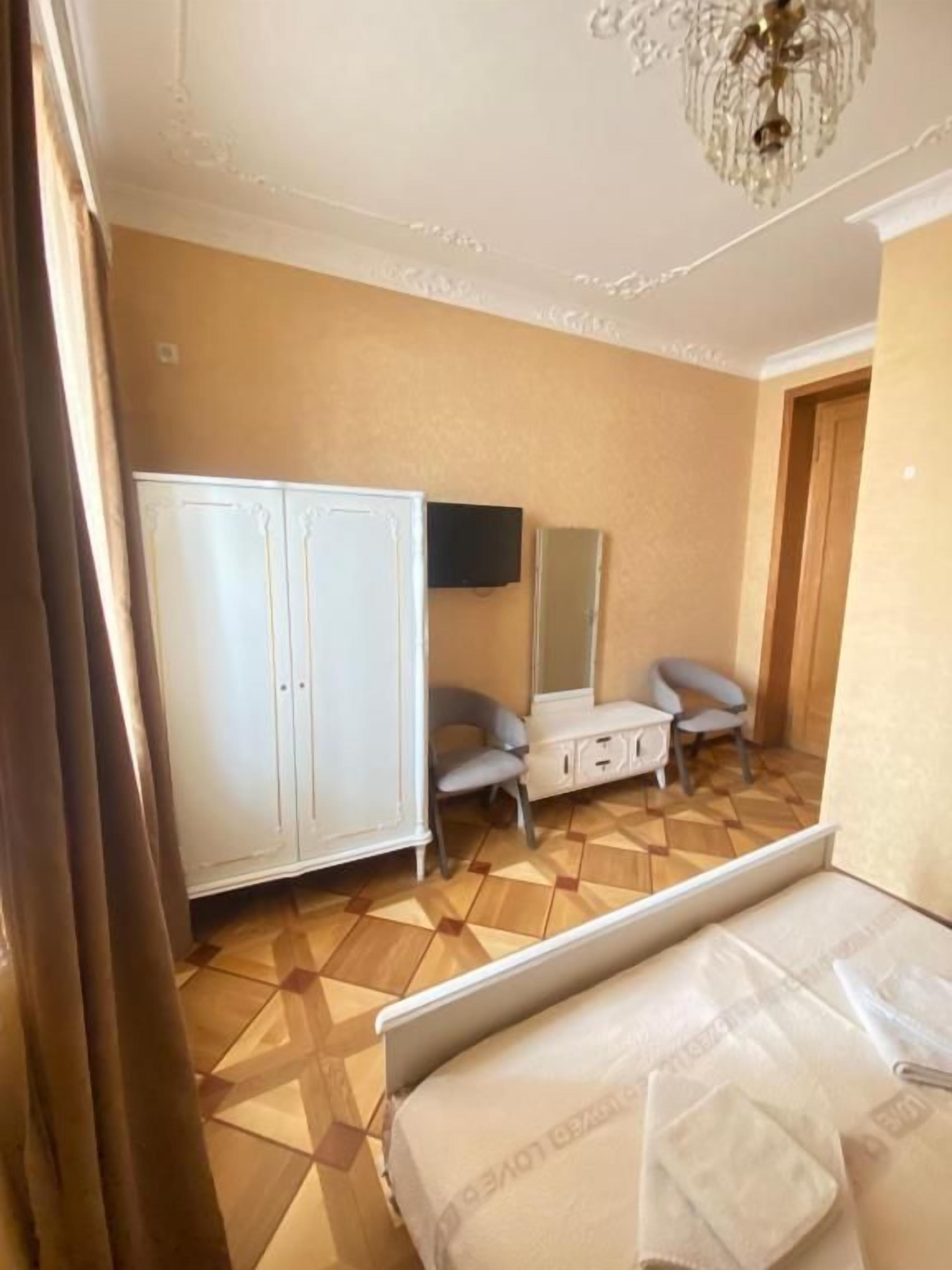 Een hotelkamer met een bed, een kledingkast, een bureau en een stoel.
