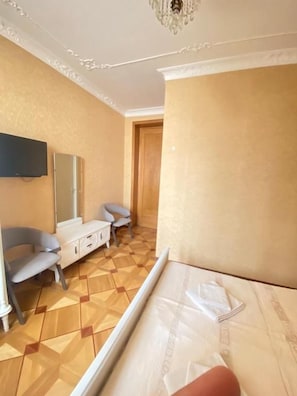 A hotel room with a bed, a TV, a desk, and two chairs. - K&N Guesthouse (Tbilisi)