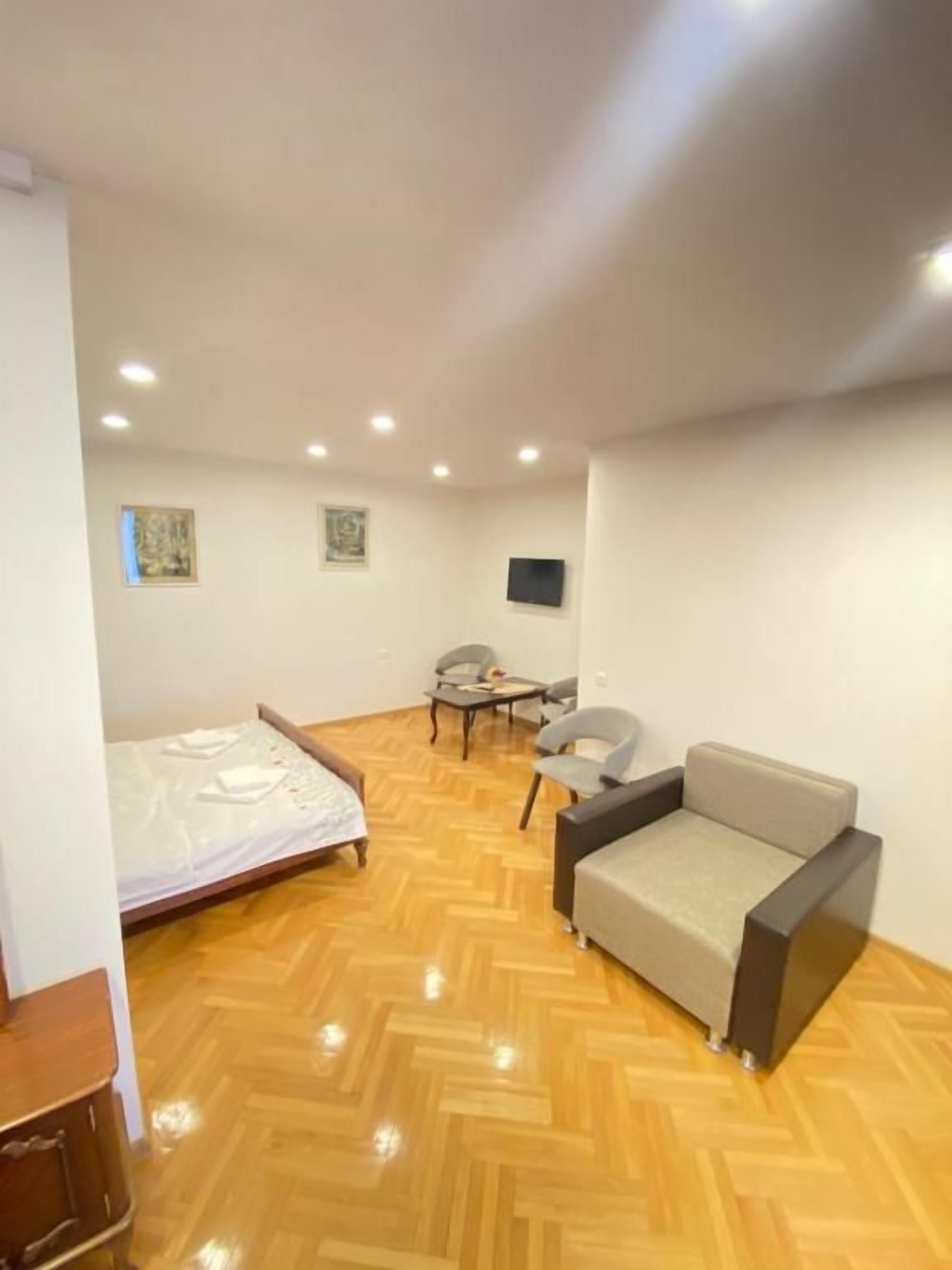 A room with a bed, a sofa, a desk, and a chair.