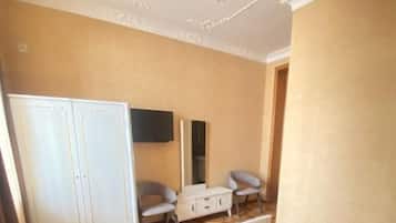 A hotel room with a bed, a wardrobe, a desk, and a chair.