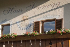 A building facade with the name 'Haus Sonnegg' and a sun emblem. - Apartment in Lajen with swimming pool (Lajen)
