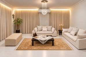 Ein modernes Wohnzimmer mit einer Sofagarnitur, einem Couchtisch und einer Deckenleuchte.