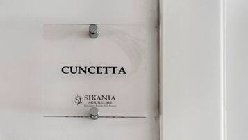 A white door with the name 'CUNCETTA' and the logo 'SIKANIA AGRIFRELAIS' indicating a restaurant and spa event.