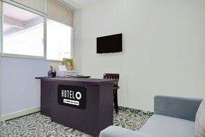 Una mesa de recepción de hotel con un cartel que indica que es un hotel 'OYO Service'.