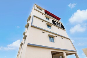 Edificio de hotel con un letrero que indica que es un hotel y ofrece servicio las 24 horas.