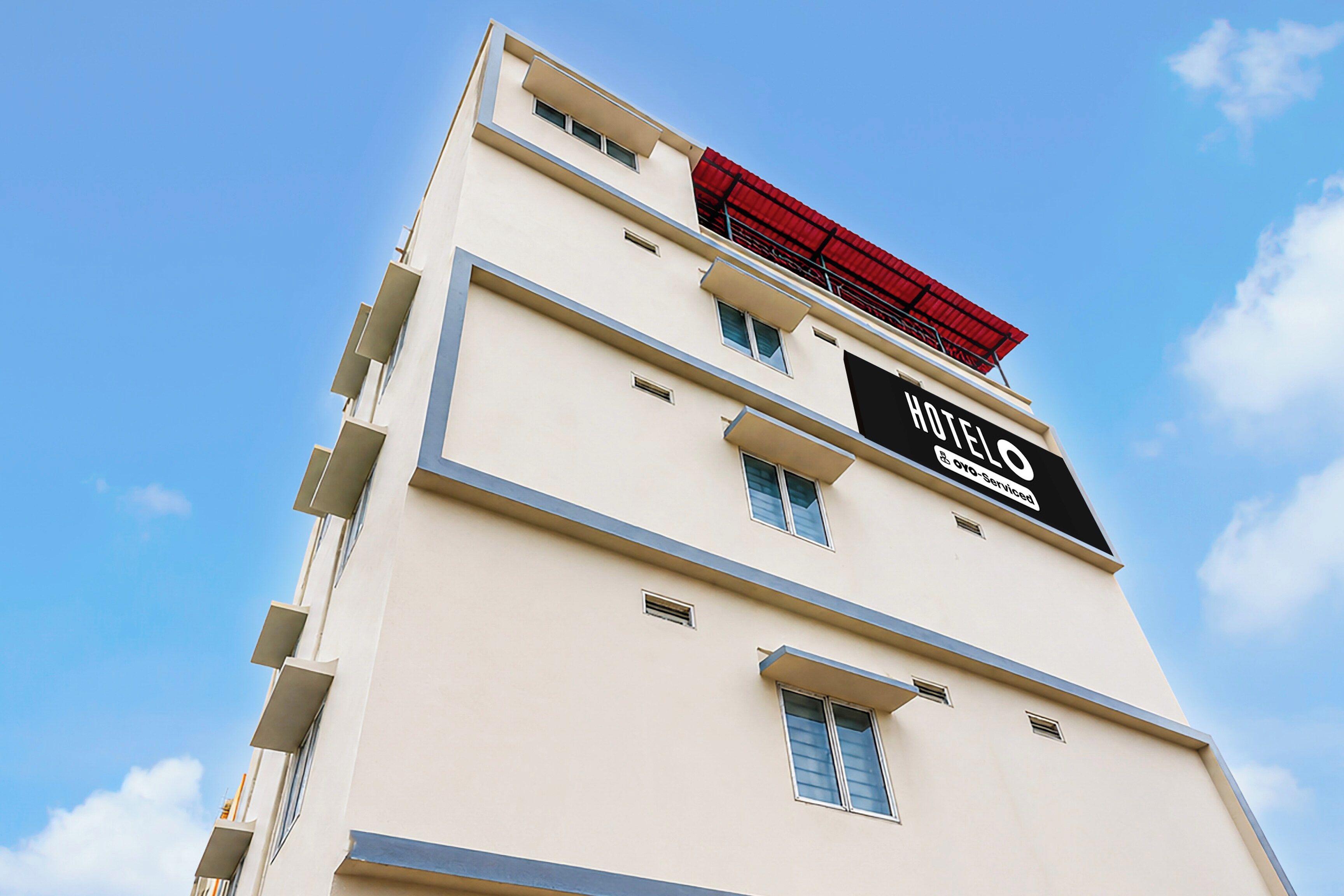 A hotel building with a sign indicating it is serviced by Agoda.