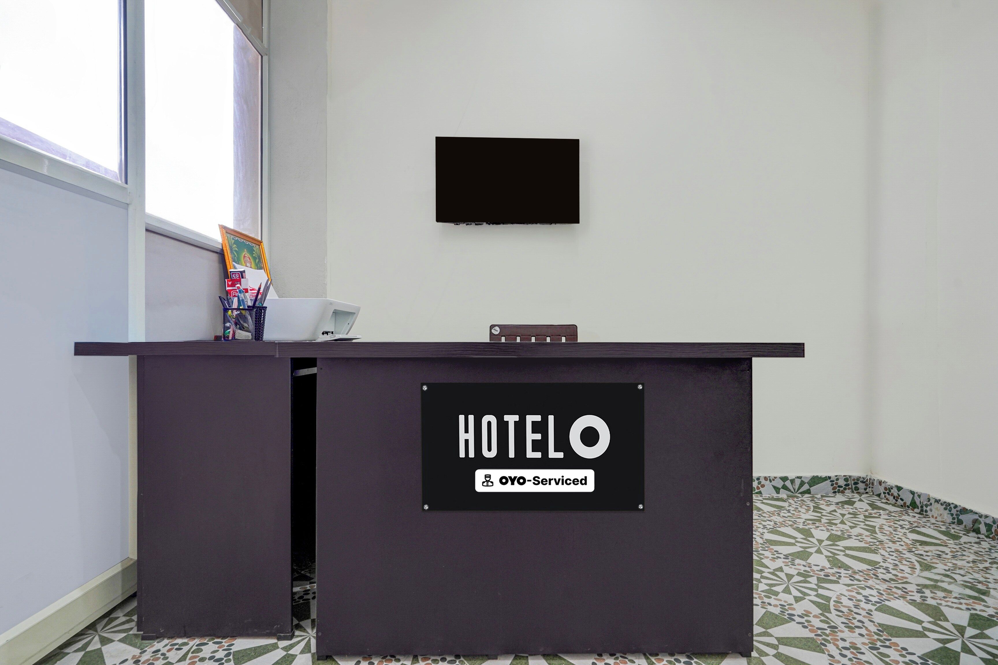 Een hotel receptiebalie met een bord waarop staat dat het wordt beheerd door OYO.
