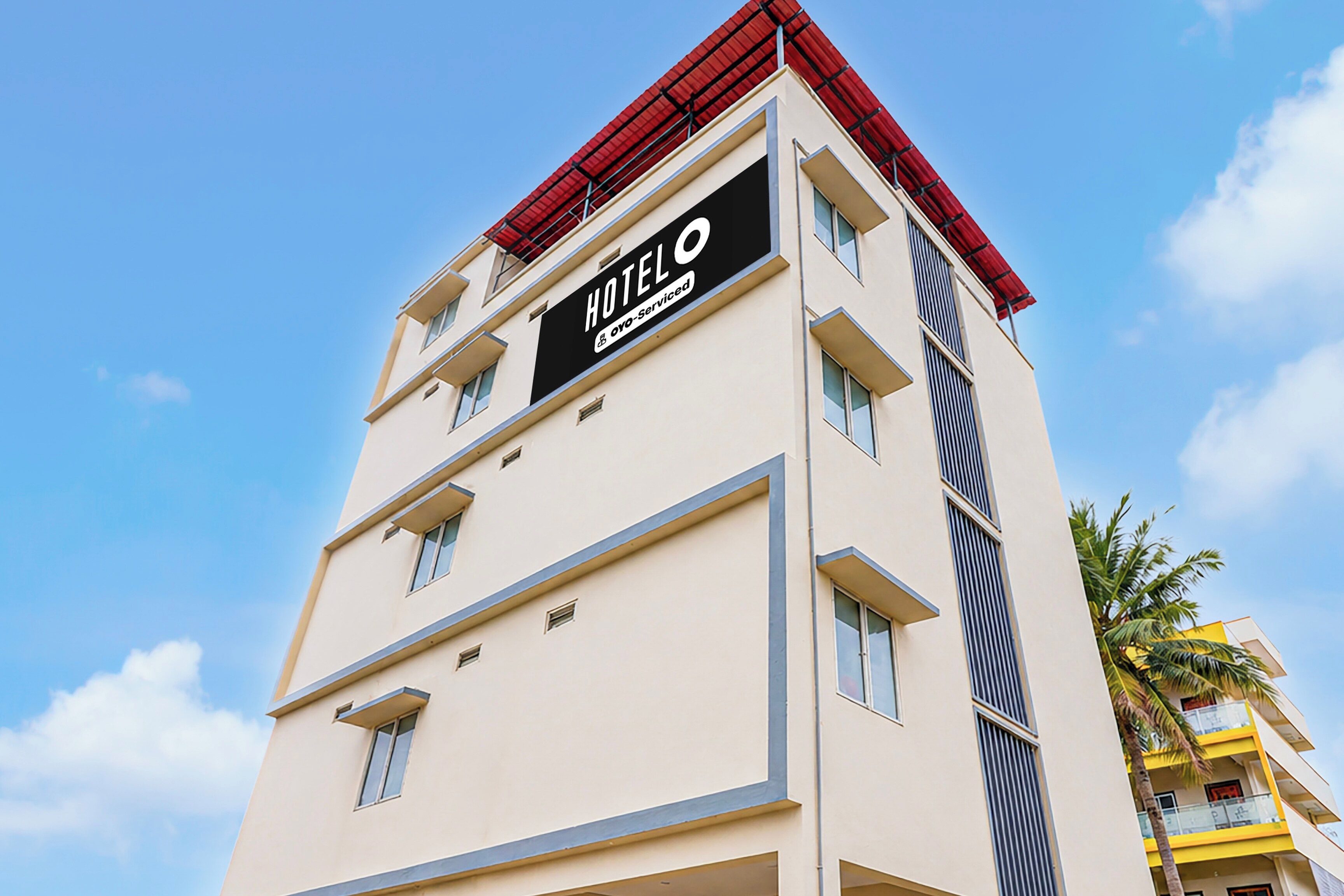 A hotel building with a sign indicating it is serviced by OYO.