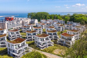 Et boligområde med moderne, høje bygninger, hvoraf nogle har balkoner, og et klart havudsigt i baggrunden.