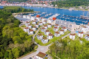 Et boligområde med moderne huse, en lystbådehavn med både og en stor bygning med swimmingpool.