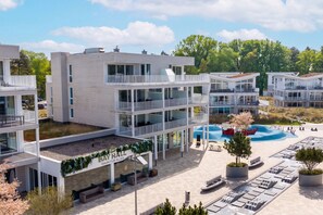 A modern multi-story hotel with balconies, a swimming pool, and a covered outdoor area. - Vrbo Property (Lübeck-Travemünde)