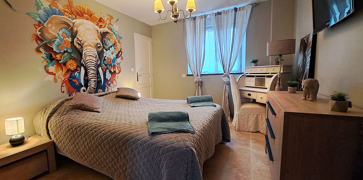 Un dormitorio con una cama grande, un aparador, un espejo y un televisor montado en la pared.