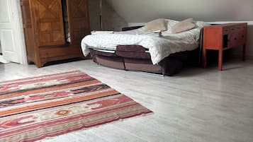 Een slaapkamer met een bed, een houten garderobe en een vloerlamp.
