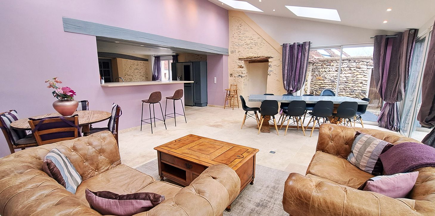 A living room with a sofa set, a coffee table, and a dining area with chairs and a table.