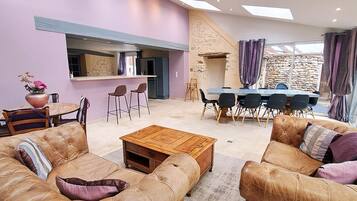 A living room with a sofa set, a coffee table, and a dining area with chairs and a table.