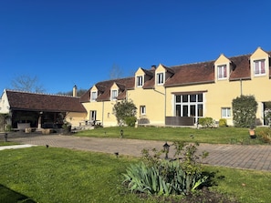 A row of yellow houses with a paved driveway and a grassy lawn.