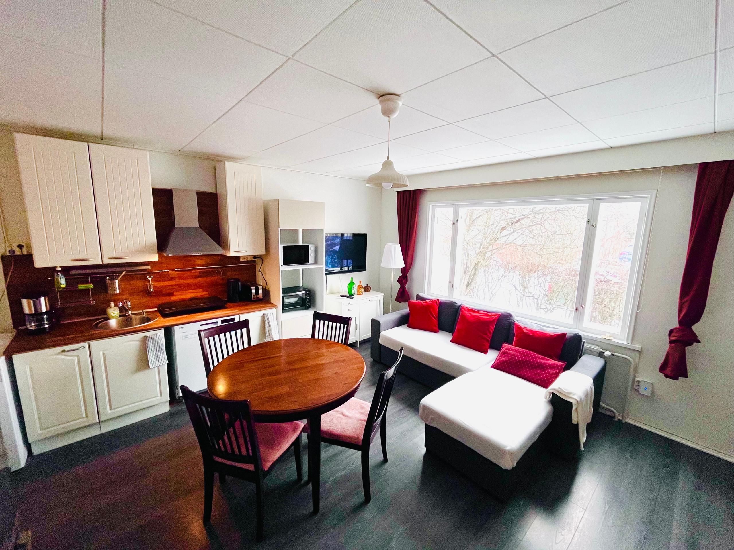 Un espace de vie compact comprenant une kitchenette, un coin repas et un coin salon.
