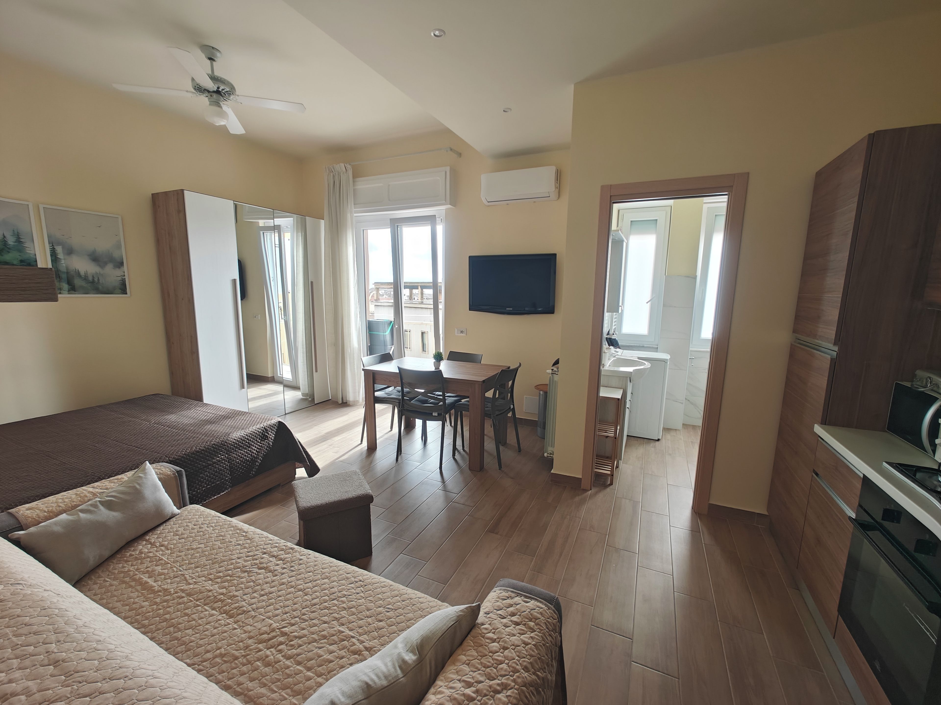 Una habitación de hotel moderna con una cama, un escritorio y una kitchenette.