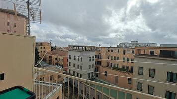 A multi-story residential building with balconies and a view of the sky.