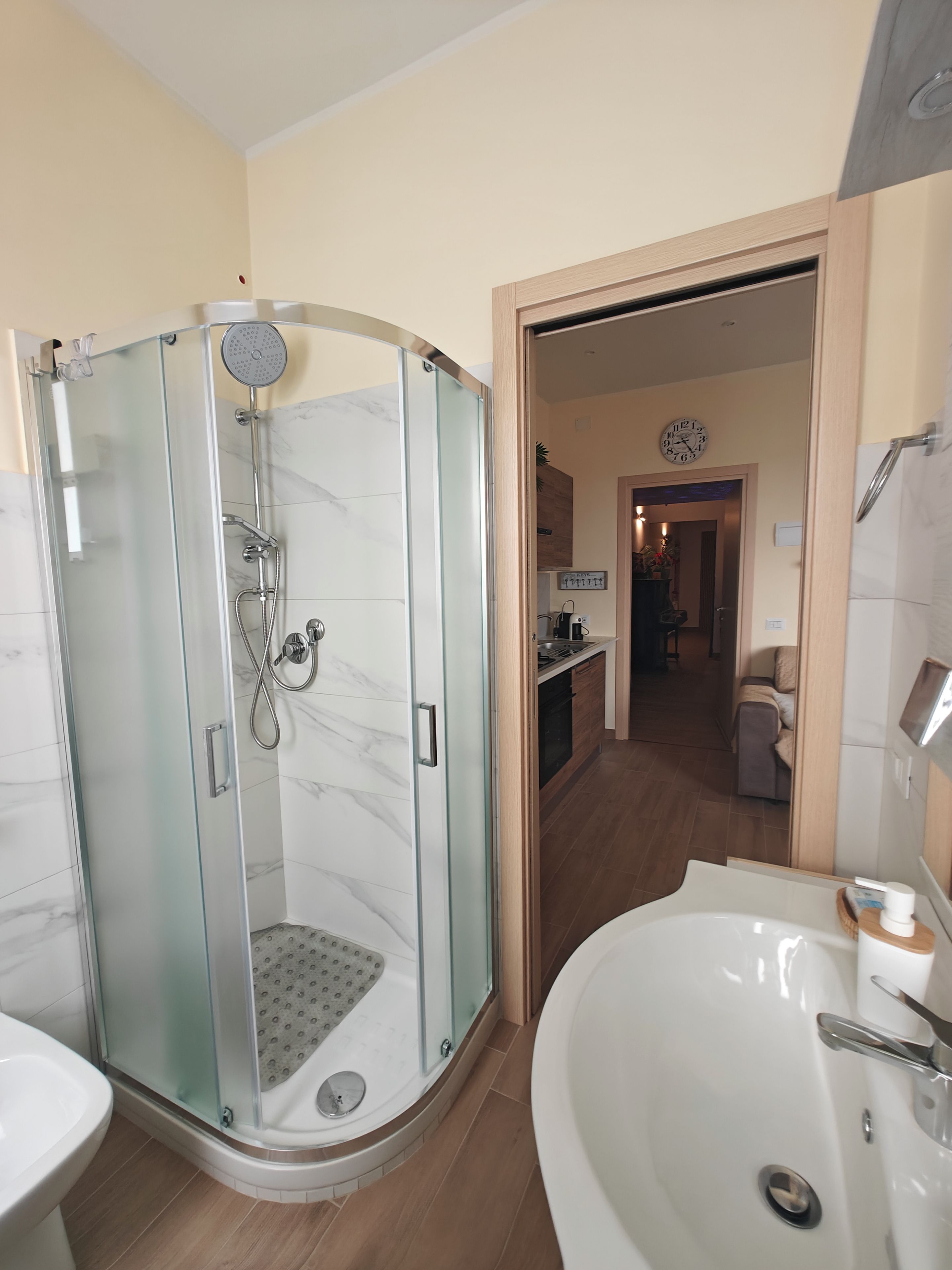 A modern bathroom with a glass-enclosed shower, a freestanding bathtub, and a sink.