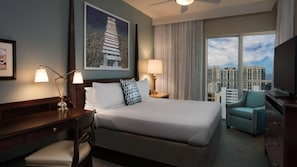 Une chambre d’hôtel avec un grand lit, un bureau, une chaise, une télévision et une vue sur la ville.