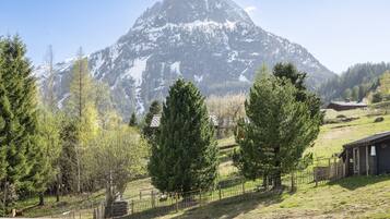 A mountain landscape with a wooden fence in the foreground.