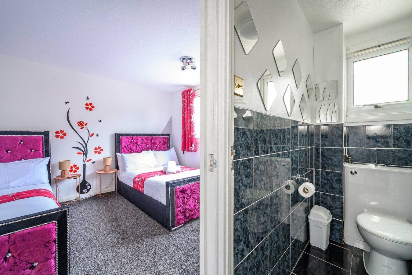 Ett hotellrum med en säng, sängbord, en lampa och en duschhörna med toalett och handfat.