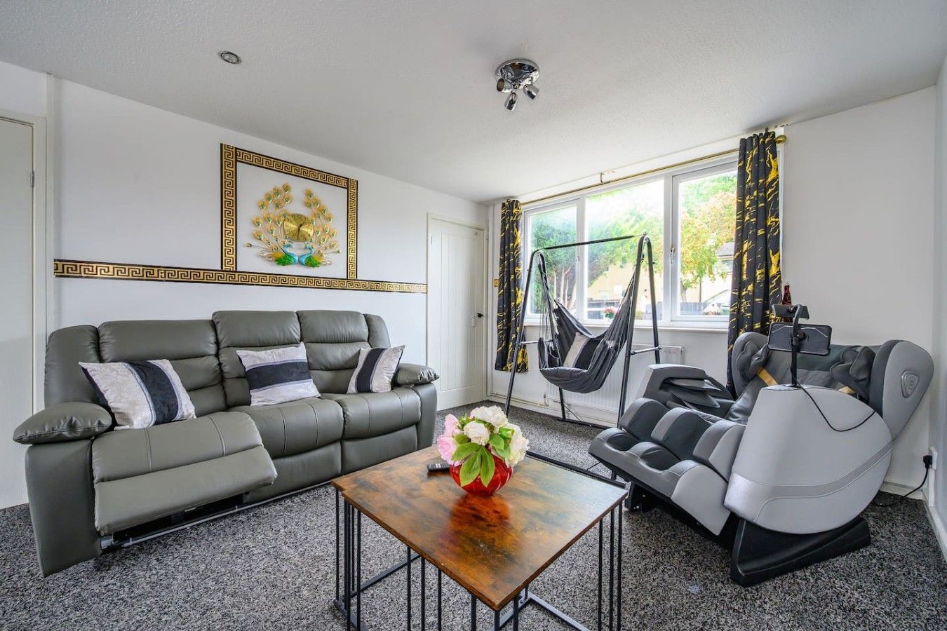A living room with a grey sofa, a wooden coffee table, and a grey recliner.