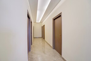 Passadís amb portes a ambdós costats, terra de rajola i sostre amb il·luminació empotrada.