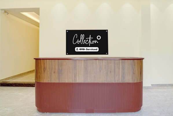 A reception desk with a sign above it that reads 'Collection OYO-Serviced'.