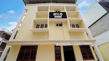 A multi-story hotel with a sign indicating it is serviced by OYO.