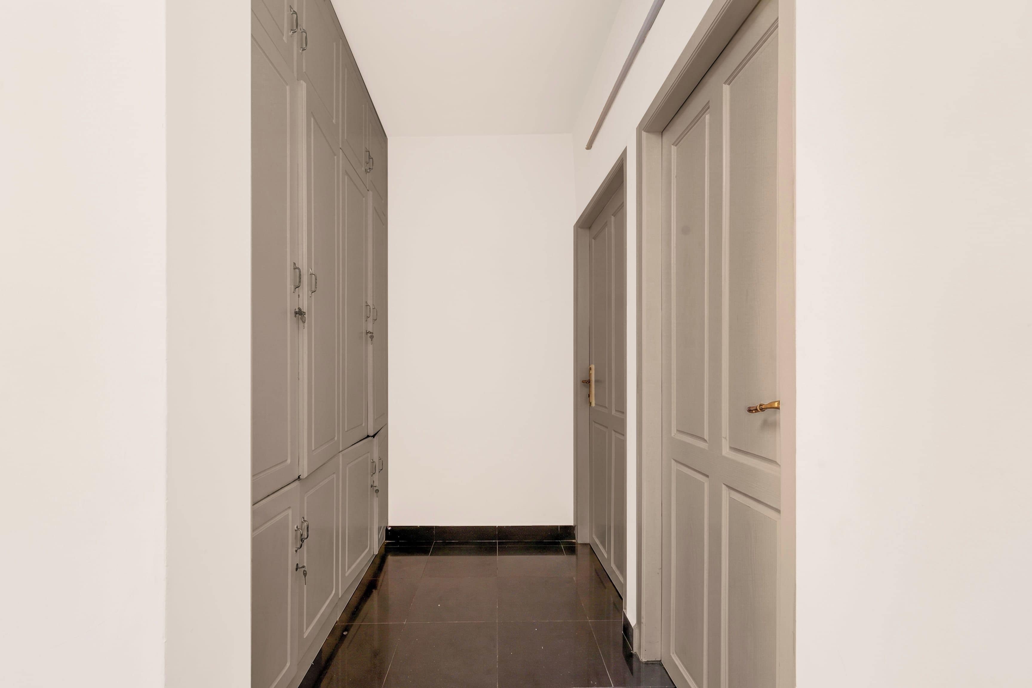 Un pasillo con puertas a ambos lados, que conduce a una habitación.