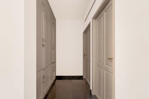 Un pasillo con puertas a ambos lados, que conduce a una habitación.