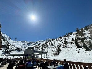 A snow-covered mountain with a clear sky and a sun shining. There is a restaurant with outdoor seating and a ski lift in the background. - Les 5 Sapins - Ski-in/Ski-out - Haute-Nendaz• 4 Vallées - Gondola 80m (Nendaz)