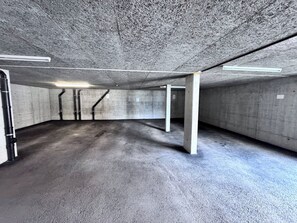 An underground parking garage with concrete pillars, a flat floor, and overhead lighting. - Les 5 Sapins - Ski-in/Ski-out - Haute-Nendaz• 4 Vallées - Gondola 80m (Nendaz)