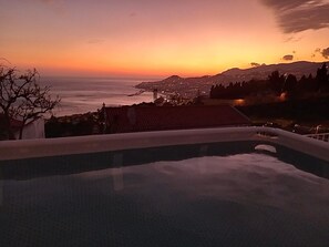A pool with a view of a sunset over a coastal landscape. - Diamant - Exclusive Villa (Funchal)