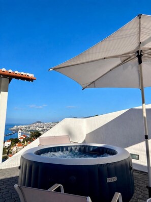 A hot tub on a rooftop terrace with a clear view of a coastal town. - Diamant - Exclusive Villa (Funchal)