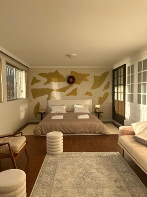 A bedroom with a large bed, two bedside tables, a rug, and a window with blinds. - Diamant - Exclusive Villa (Funchal)