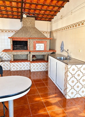 A kitchen with a built-in oven, a sink, and a dining table. - Diamant - Exclusive Villa (Funchal)