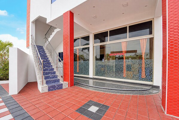 A modern building with a reception area, a staircase with marble steps, and a red and white color scheme. - Townhouse Kanyakumari Bus Terminal (Nagercoil)